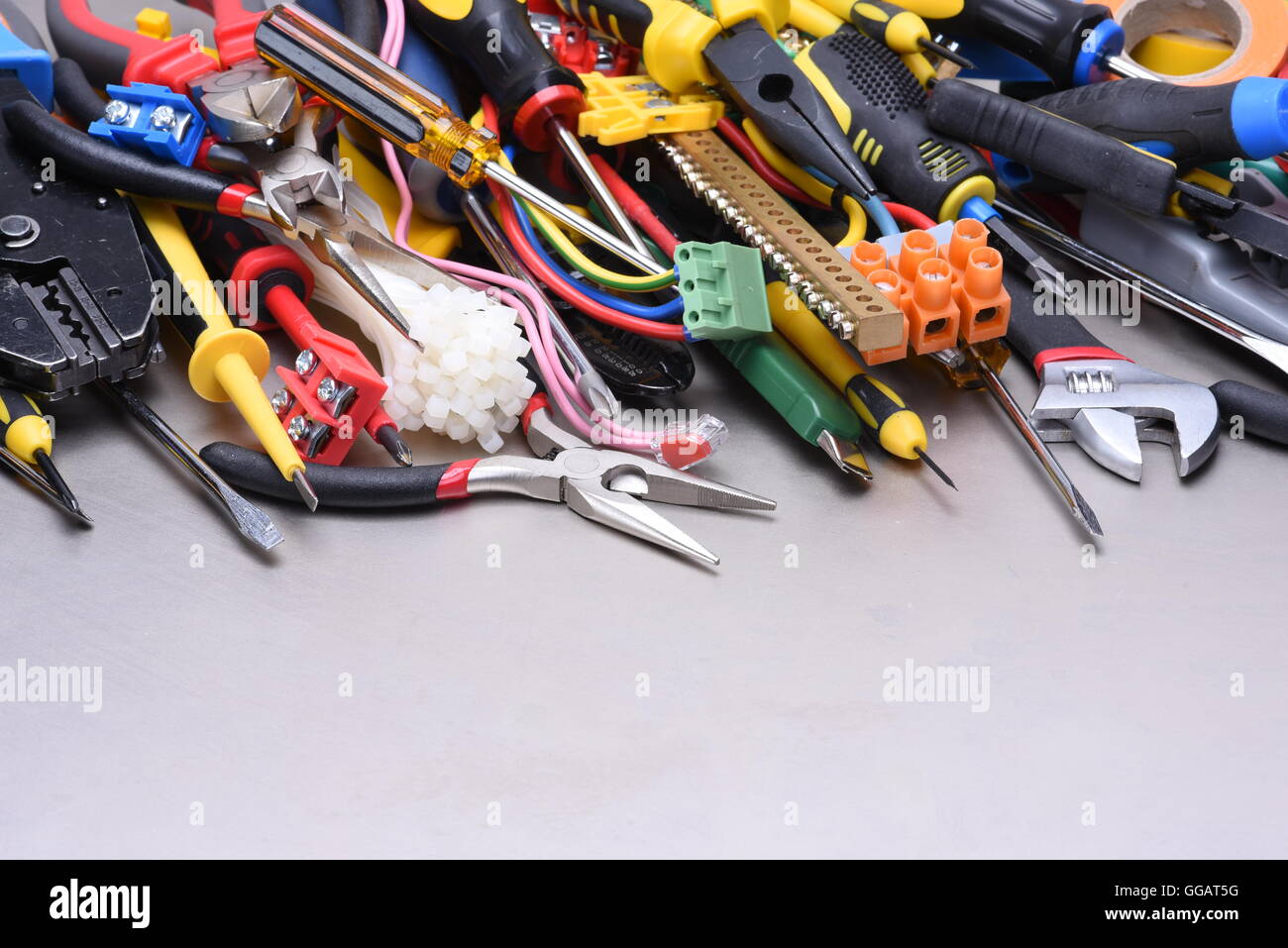 Gruppo di strumenti, accessori e componente utilizzato in installazioni elettriche su metallo grigio tabella una copia gli spazi con sfondo Foto Stock