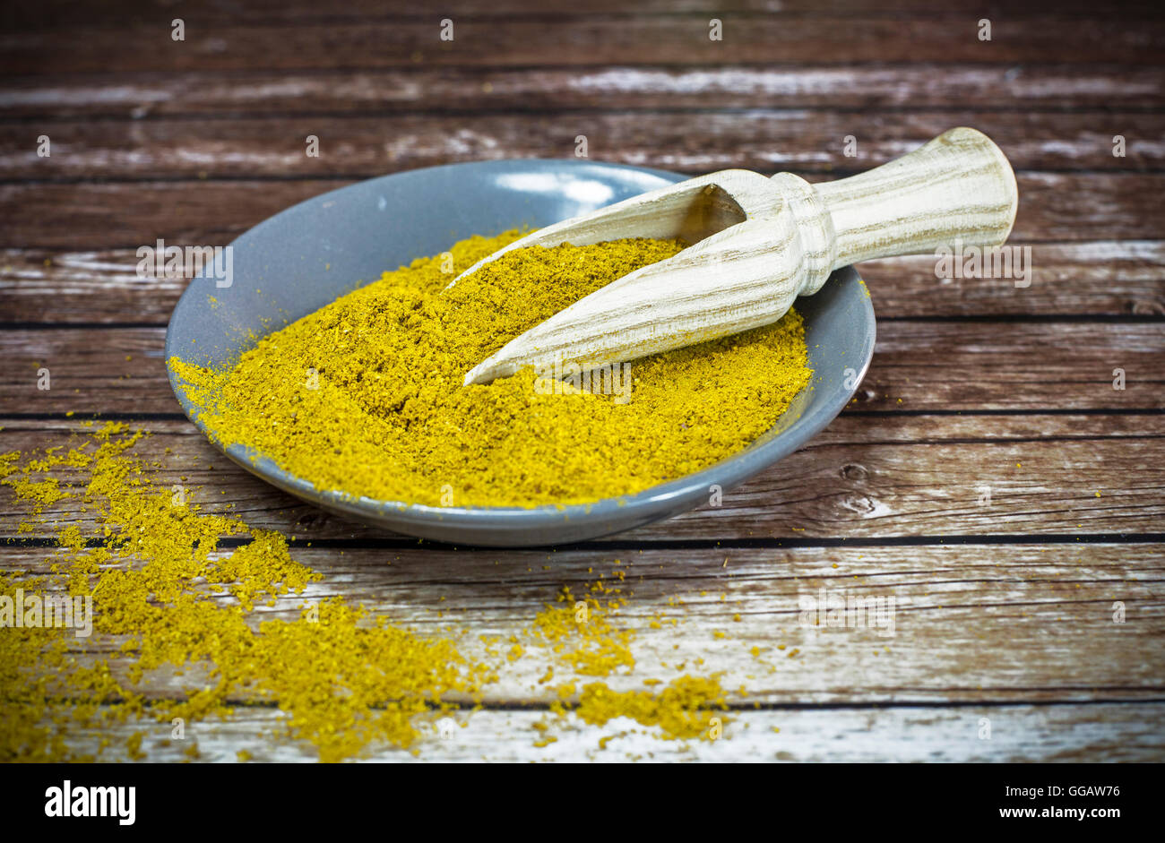 Piastra piccola di curry in polvere con il cucchiaio di legno Foto Stock