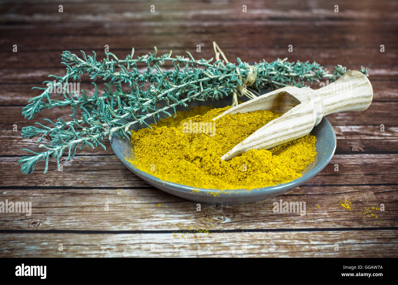 Piastra piccola di curry in polvere con il cucchiaio di legno Foto Stock