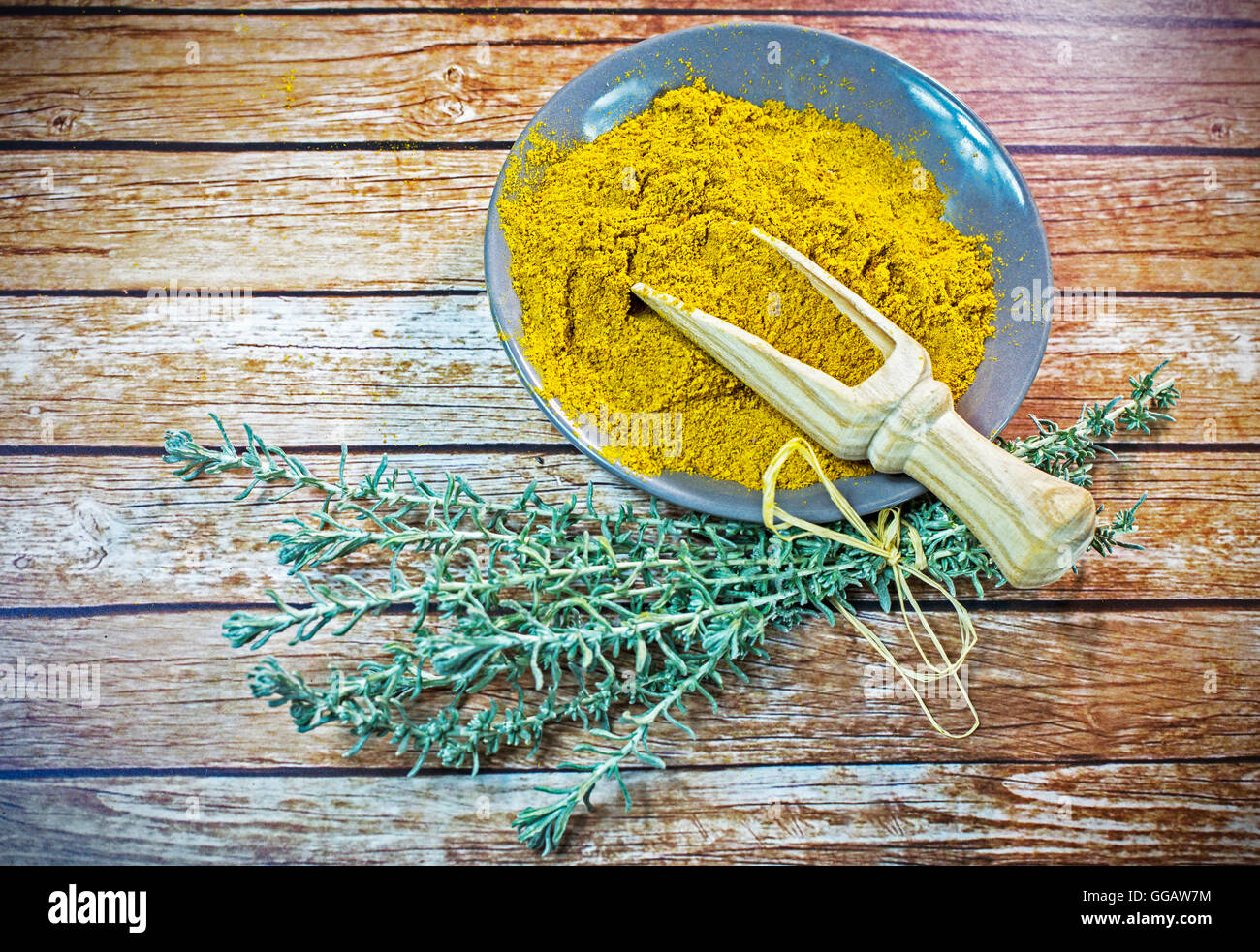 Piastra piccola di curry in polvere con il cucchiaio di legno Foto Stock