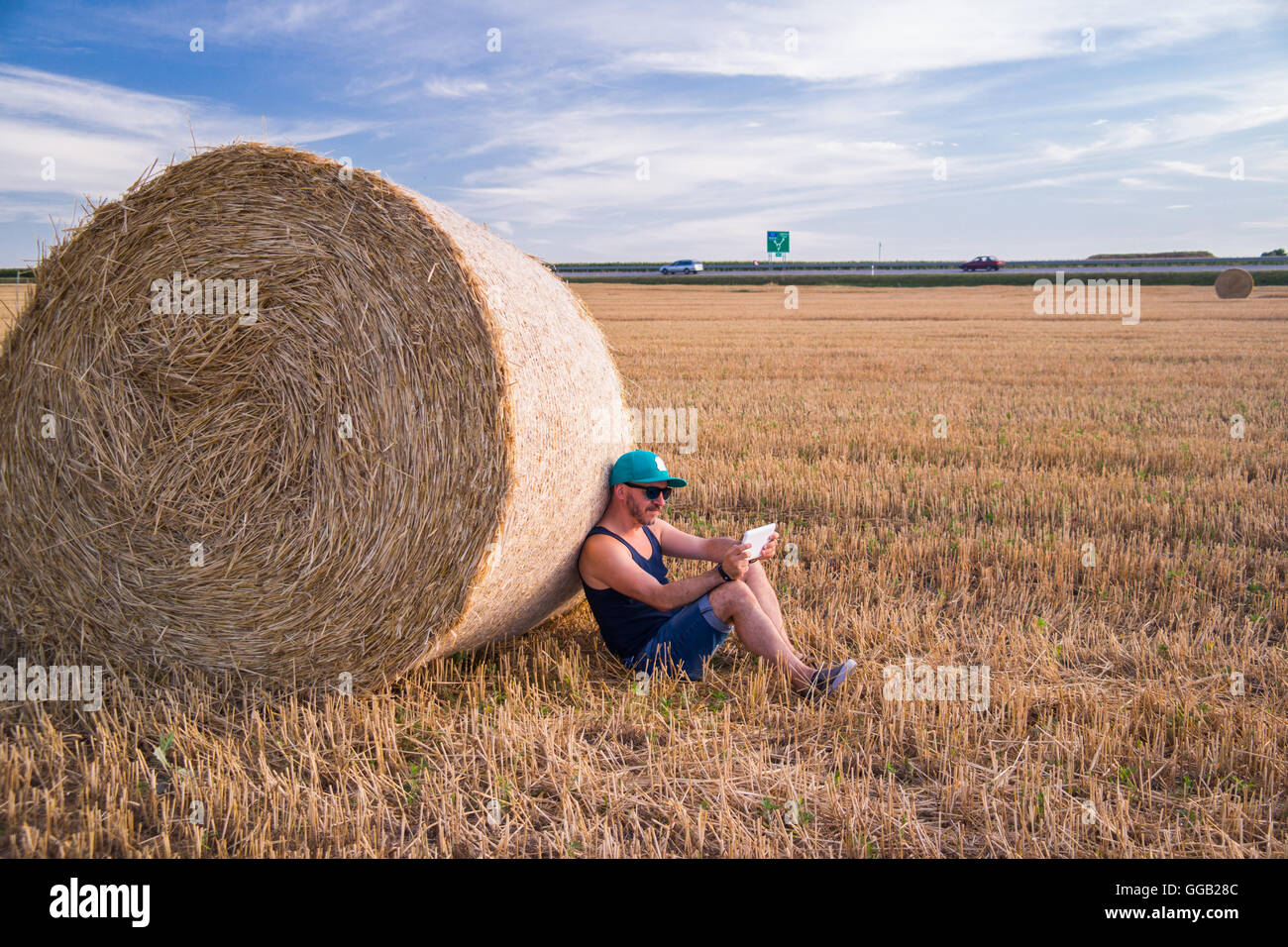 Un giovane maschio con tavoletta su un campo di grano. Foto Stock