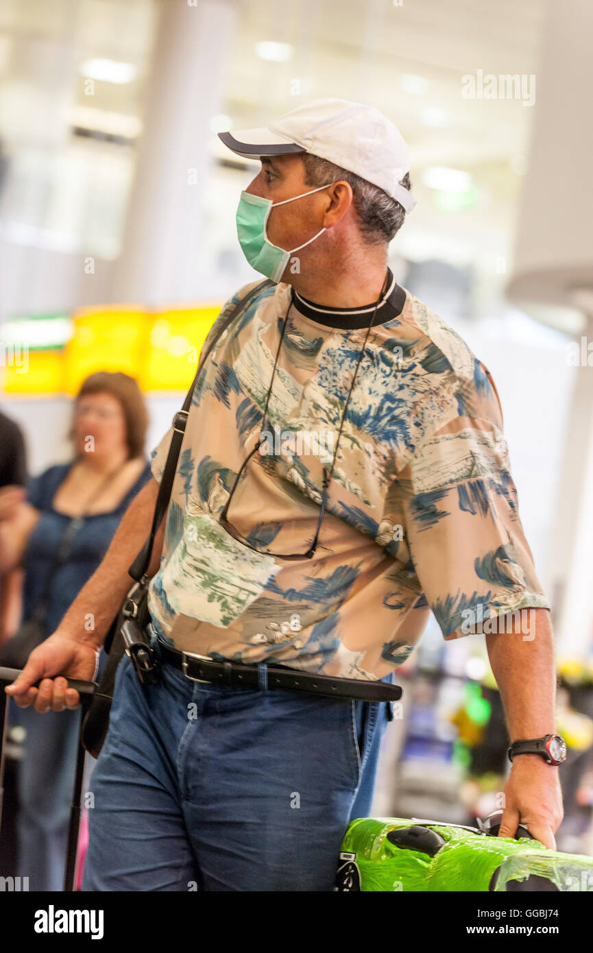 I passeggeri che arrivano su un piano da Italia faccia indossare maschere a filtro per proteggere contro il Regno Unito di influenza suina. Foto Stock