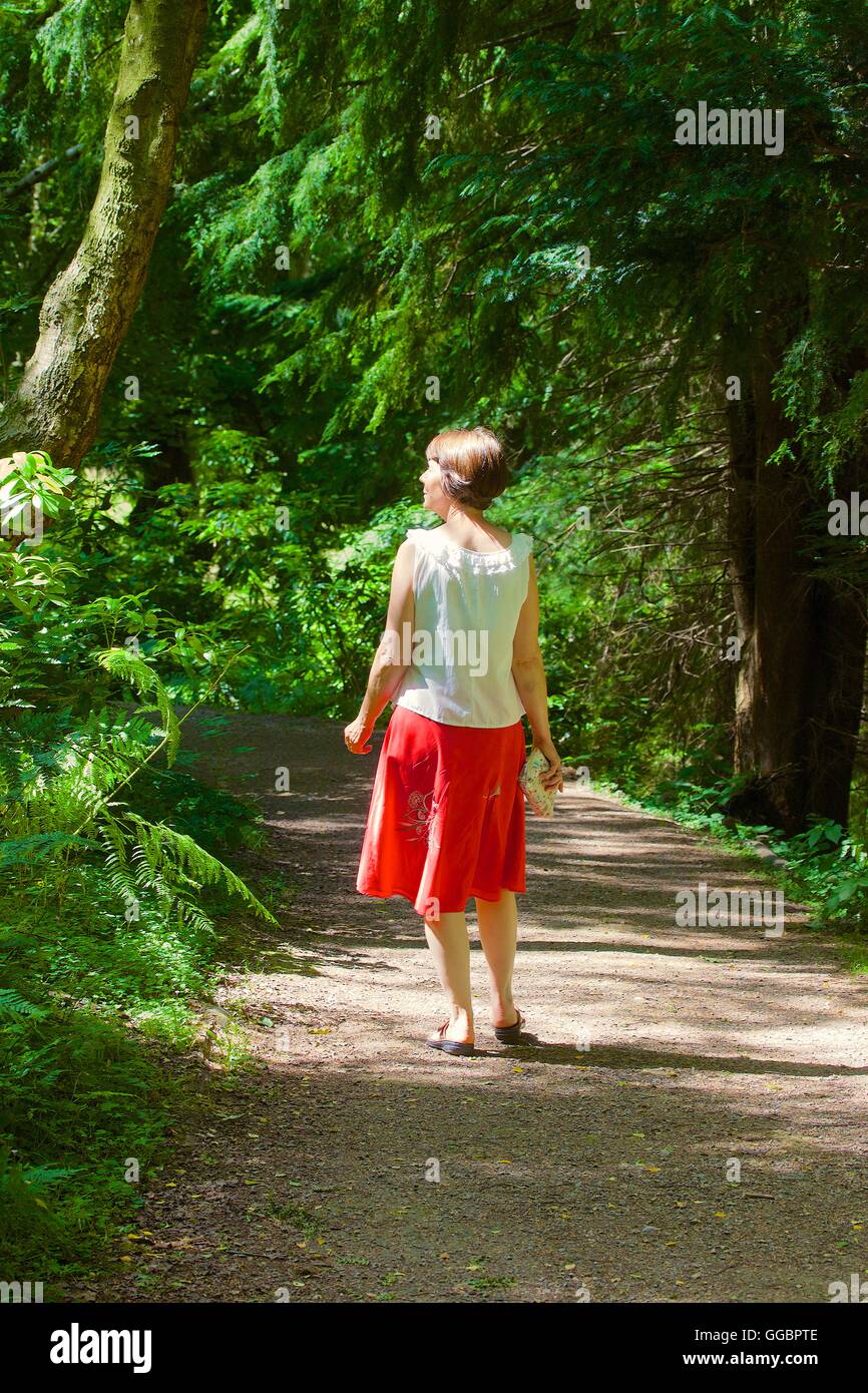 Donna che cammina sul sentiero nel bosco. Gibside, Rowlands Gill, Gateshead, Tyne & Wear, England, Regno Unito, Gran Bretagna, Europa. Foto Stock