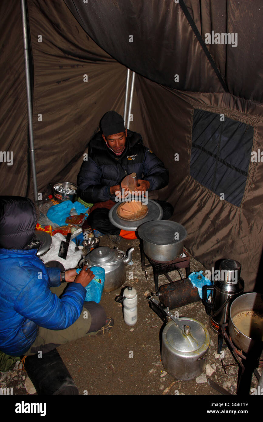 Sherpa / cuoco preparare il cibo in puck tenda ad alta camp - Mera peak - Crepuscolo Foto Stock