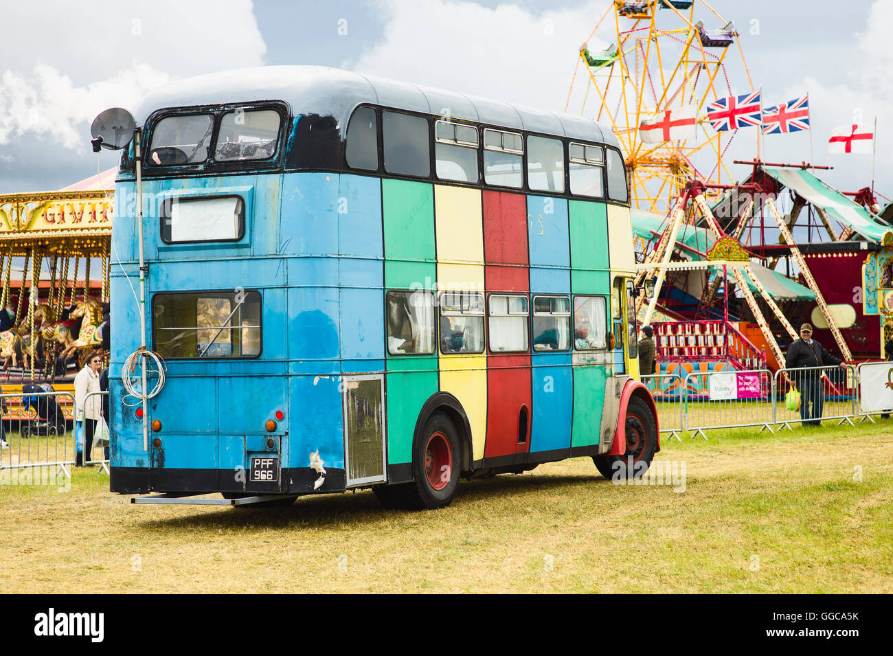 Multi-striped vecchio omnibus sfilando in un inglese visualizza Foto Stock