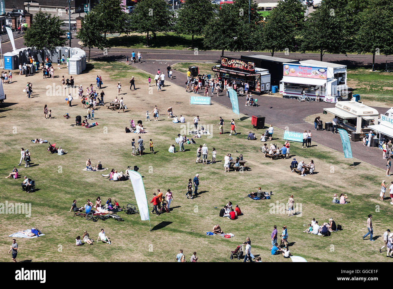 Una vista in elevato di gruppi di famiglie e gruppi di amici godendo il sole su Glasgow Green durante il Glasgow Visualizza. Foto Stock