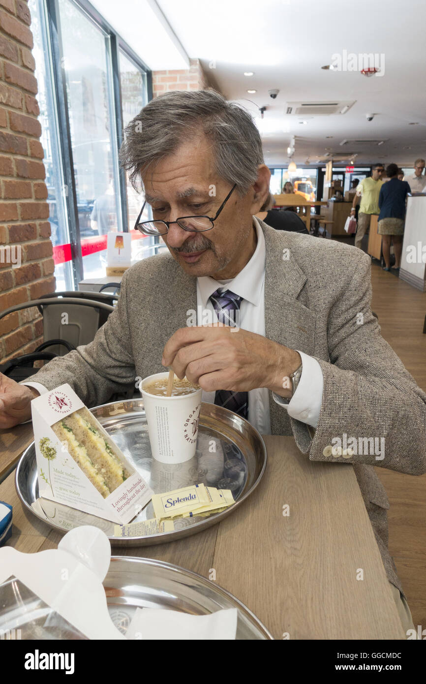 Uomo anziano afferra un panino e caffè in una Pret lungo la Quinta Avenue nel centro di Manhattan. Foto Stock