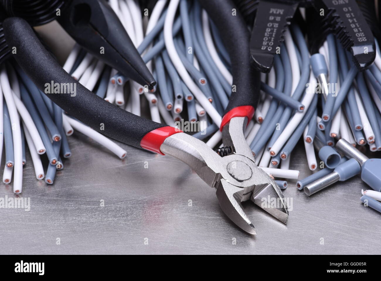 Strumenti per elettricista e i cavi grigio sulla superficie metallica Foto Stock