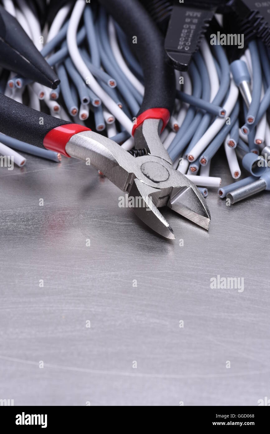 Strumenti per elettricista e i cavi grigio sulla superficie metallica Foto Stock