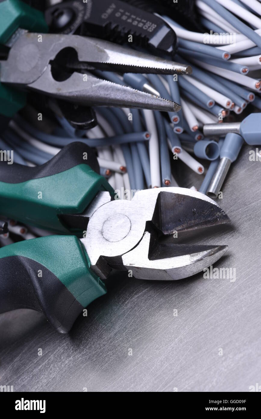 Strumenti per elettricista e i cavi grigio sulla superficie metallica Foto Stock