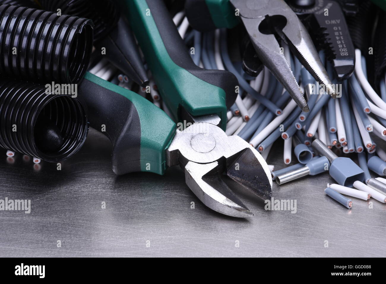Strumenti per elettricista e i cavi grigio sulla superficie metallica Foto Stock