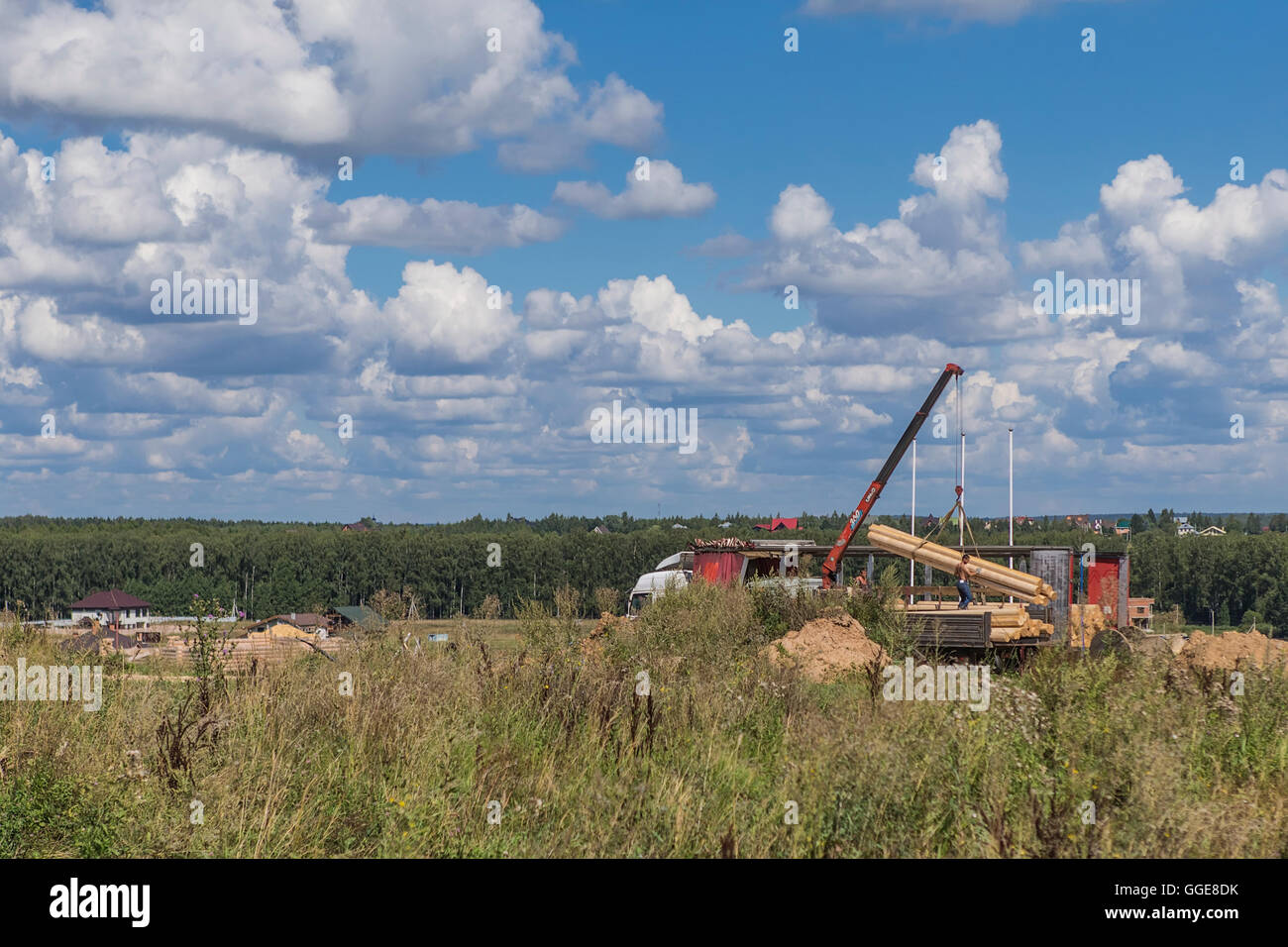 Lavoratori edili scaricare materiali da costruzione gru Foto Stock