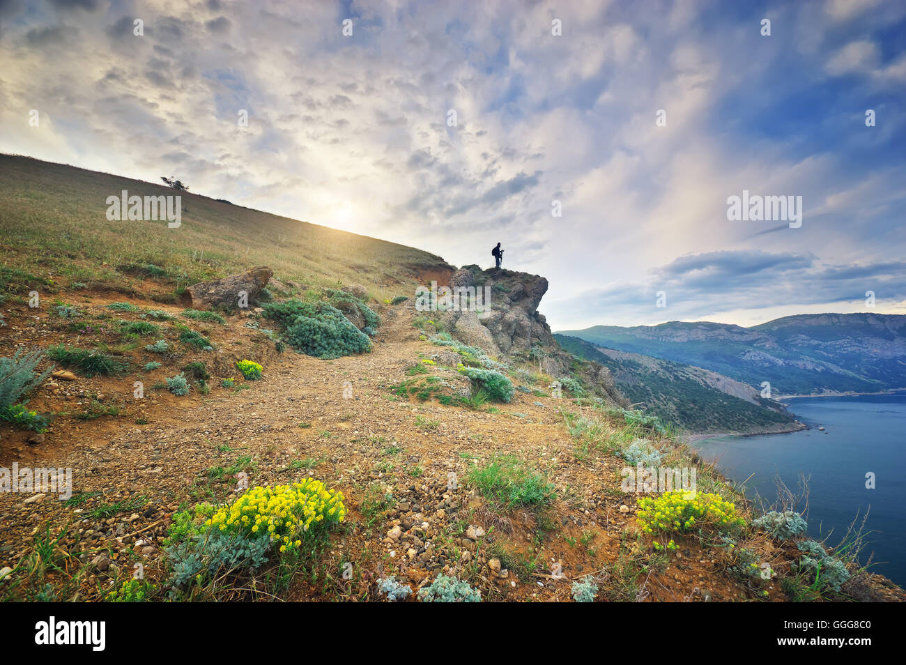 Traveler in montagna. Fotografo in montagna vicino al mare Foto Stock