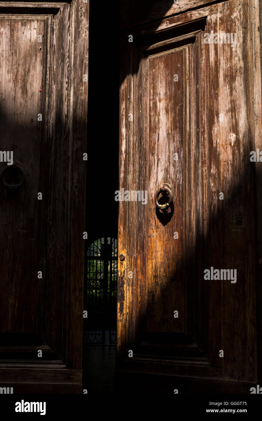 Respingente sul aprire porta in legno che conduce ad un cortile in Firenze, Toscana, Italia Foto Stock