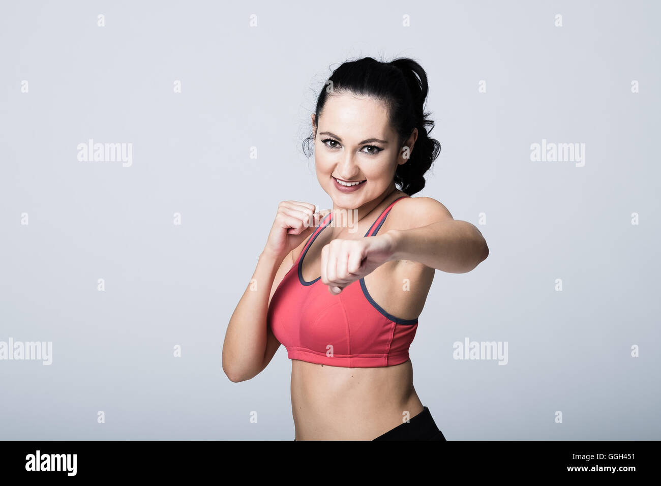 Donna nella sua 20s in attrezzature fitness punzonatura attraverso Foto Stock