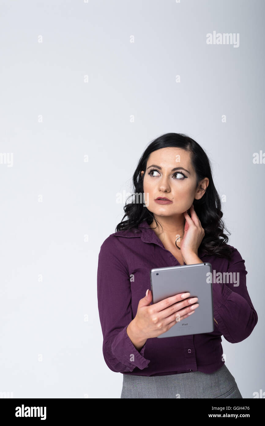 Donna d'affari che si concentra su un'attività di lavoro con un tablet. Immagine con orientamento verticale con spazio di copia in alto a sinistra della cornice Foto Stock