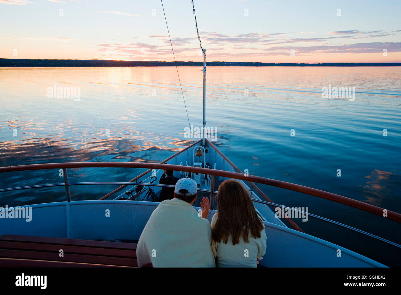 Giovane seduto sul ponte di una nave, Ammersee, Alta Baviera, Baviera, Germania Foto Stock