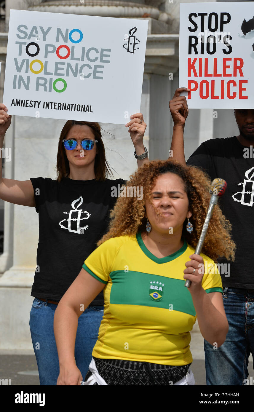 Un gruppo di dimostranti di Amnesty International protesta dichiarando 'say no alla violenza della polizia in Rio', con una banda di batteristi di Samba a Marble Arch a Londra. Foto Stock