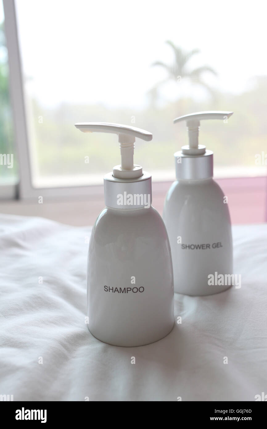 Flacone bianco di shampoo sul tessuto in casa. Foto Stock