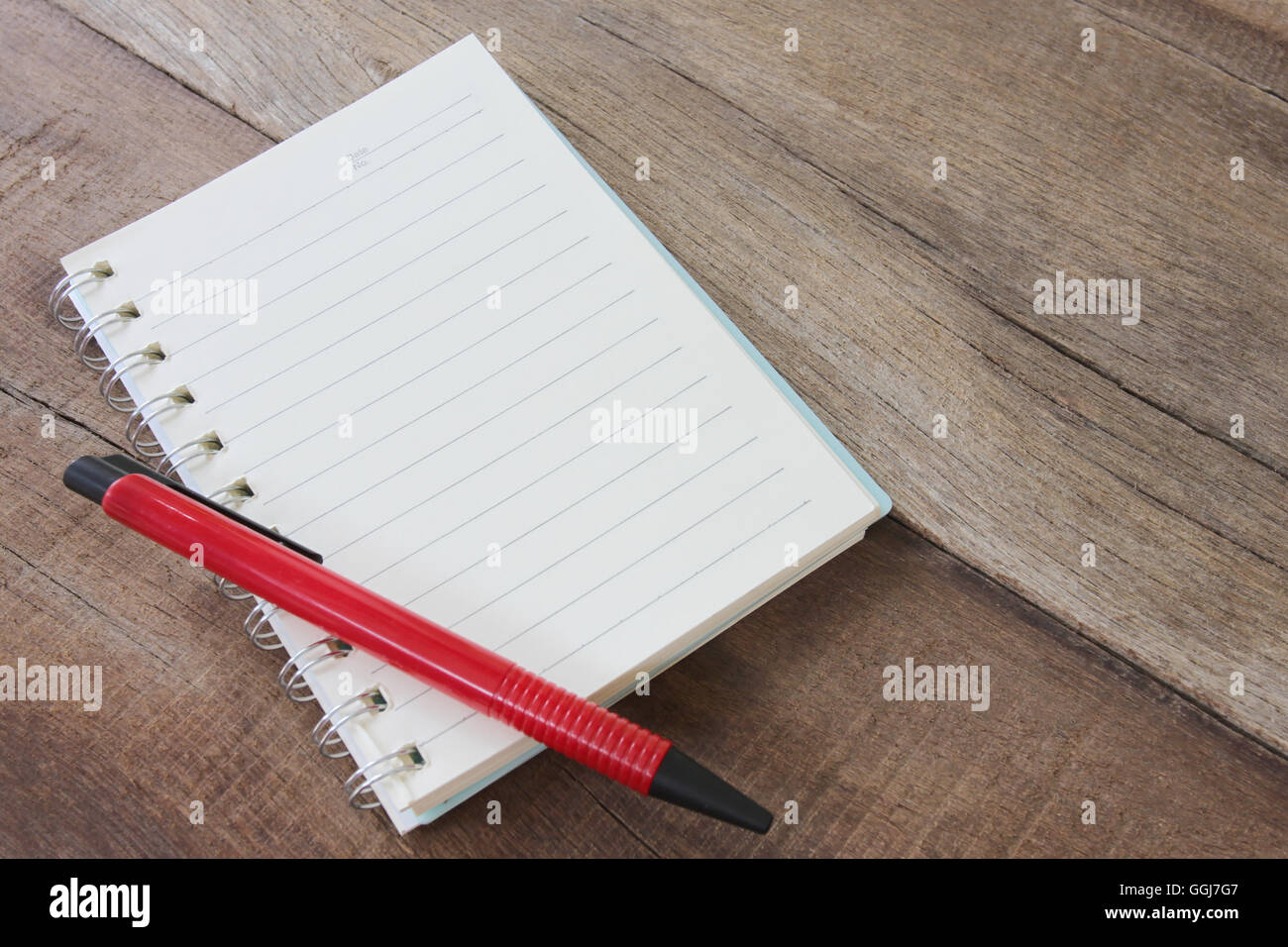 Notebook vuota e il colore della penna sul pavimento in legno per la progettazione dello sfondo. Foto Stock