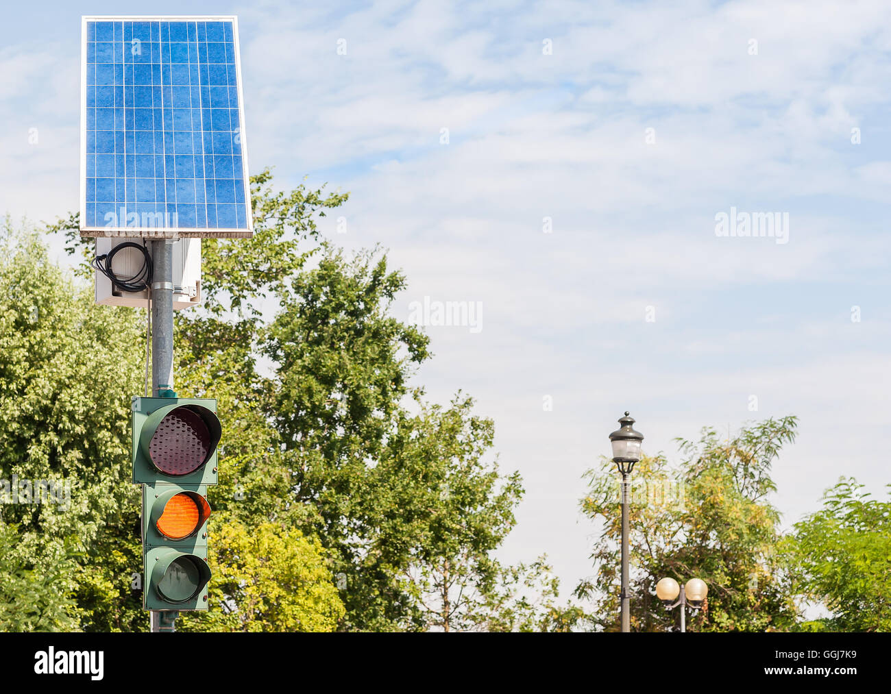 Il traffico su strada luce alimentato da energia elettrica generata da un pannello solare Foto Stock