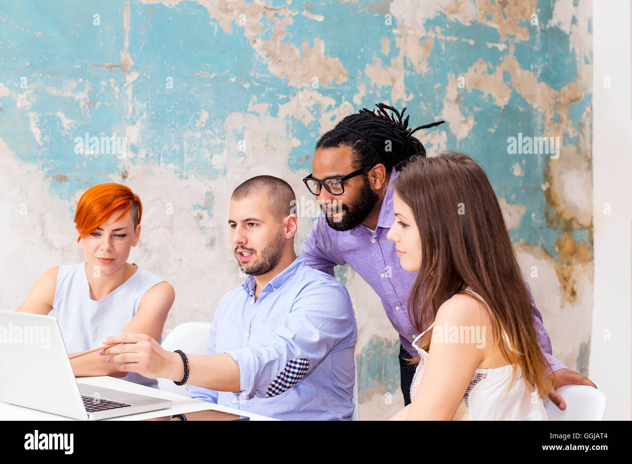 Giovani che lavorano con la scrivania in ufficio grunge Foto Stock
