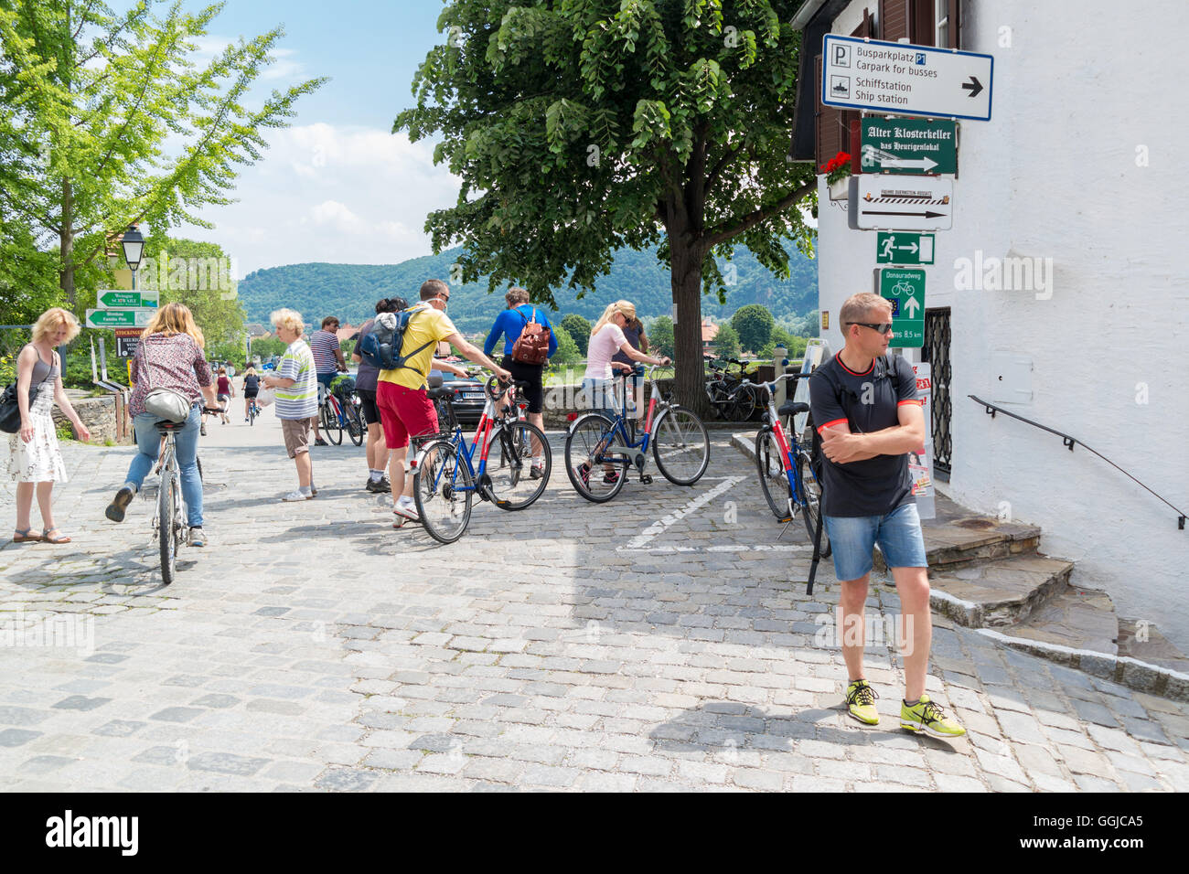 Le persone in vacanza con le biciclette in via principale della città vecchia di Durnstein nella valle di Wachau, Austria inferiore Foto Stock