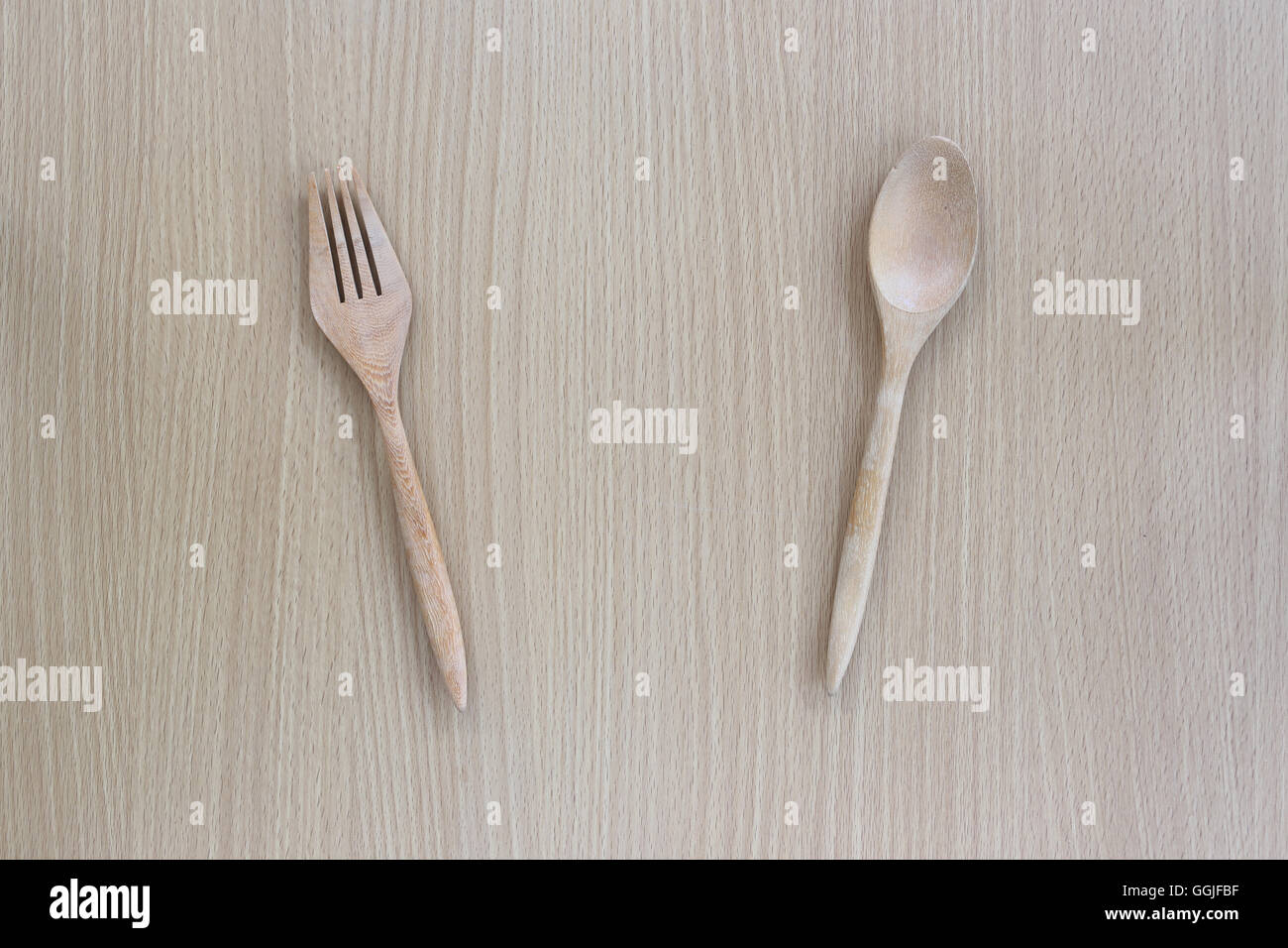 Il cucchiaio di legno e la forcella in vista dall'alto su uno sfondo di legno per il design concept food. Foto Stock