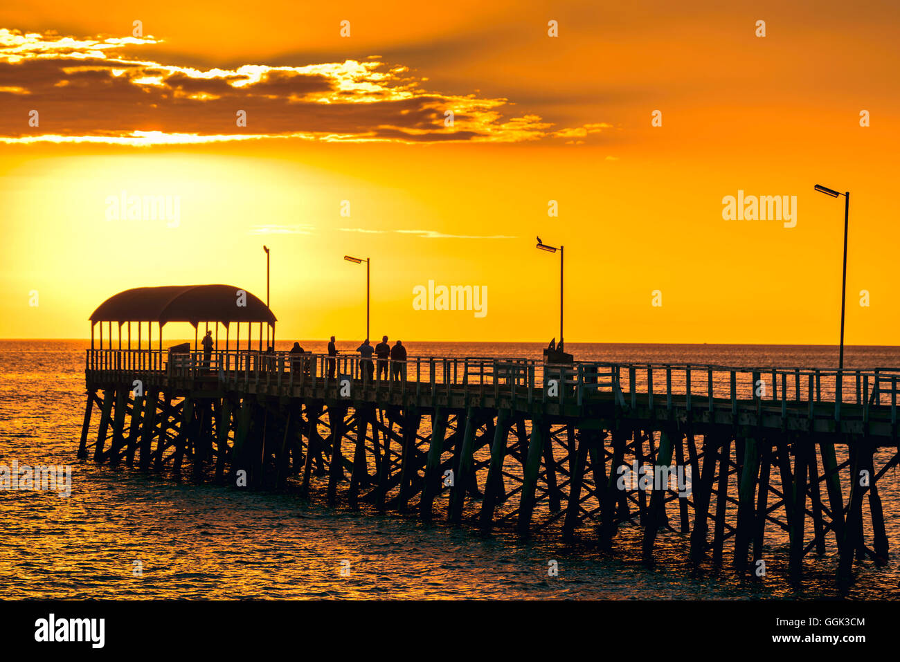 Persone su Henley Beach molo al tramonto, South Australia. Color-tonificante applicato Foto Stock