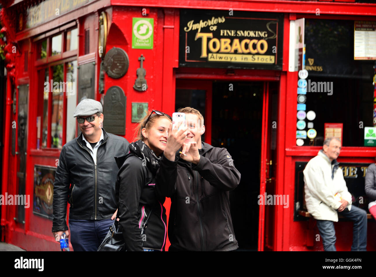 Giovane prendendo un selfie al di fuori di un pub in Temple Bar trimestre, Dublino, Irlanda Foto Stock