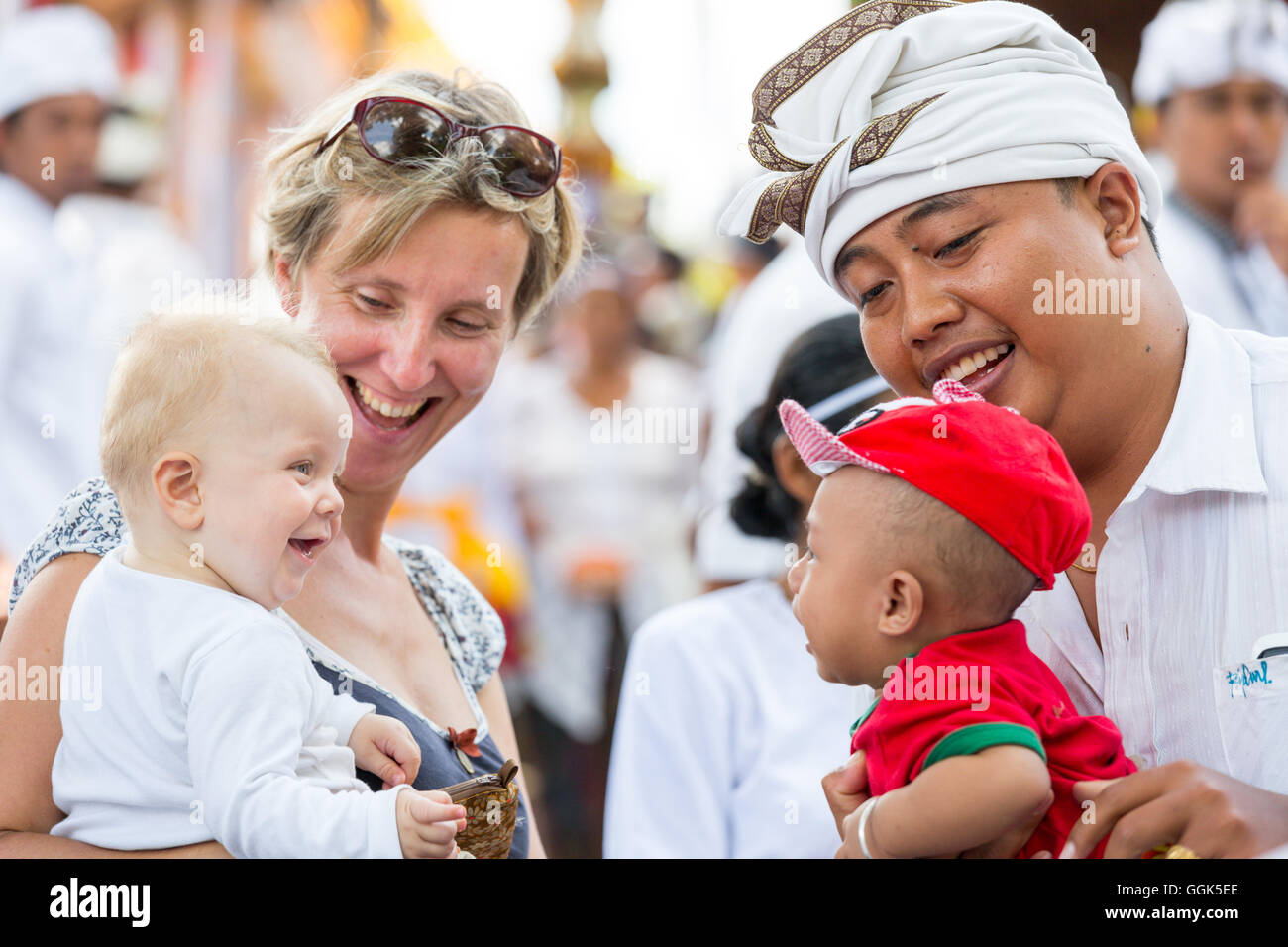 Padre Balinese con bambini, Tedesco madre con bambino e bambina di 5 mesi di età, giocare insieme, ridere, sorridente, tempio cerimonia, Foto Stock