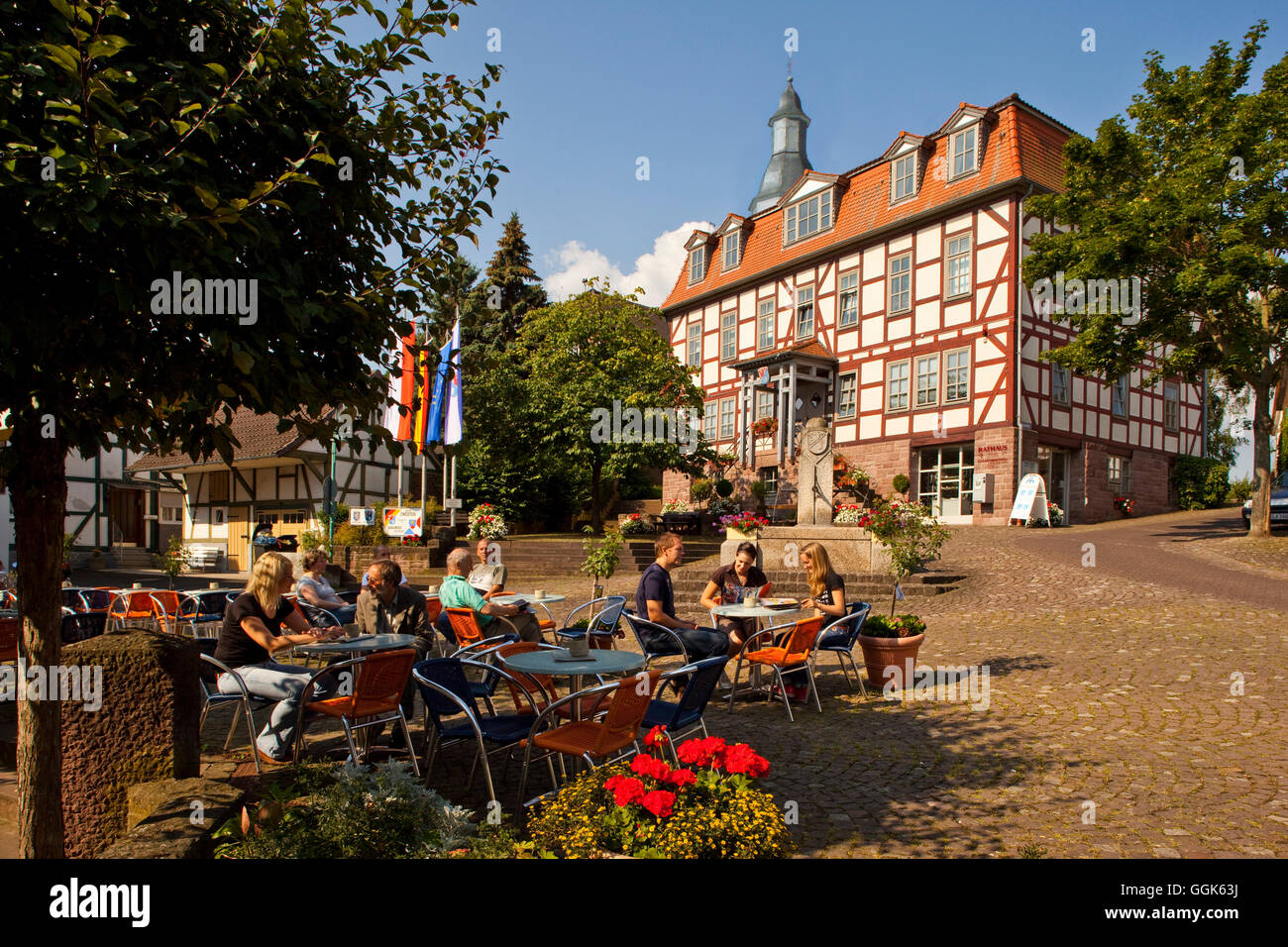 La gente seduta al di fuori di un cafè sulla Marktplatz piazza del mercato di fronte al municipio, Bad Zwesten, Hesse, Germania, Europa Foto Stock