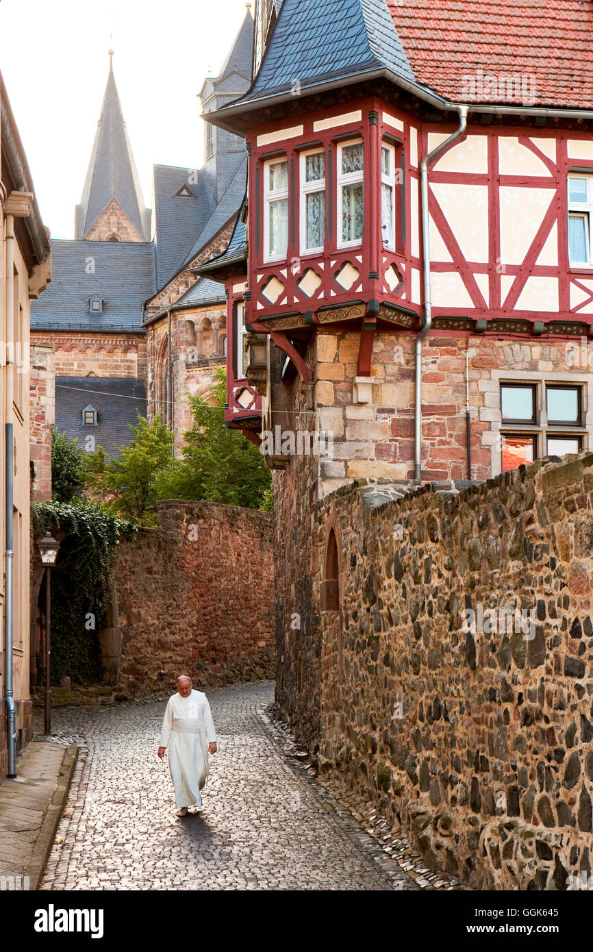 Un monaco percorrendo a piedi il Titusgasse vicolo dietro la cattedrale di Fritzlar, Fritzlar, Hesse, Germania, Europa Foto Stock