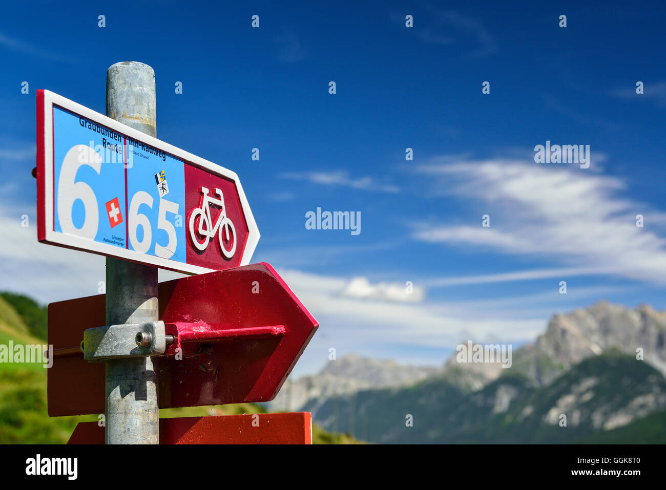 Percorso ciclabile cartello con le montagne sullo sfondo, Bassa Engadina Cantone dei Grigioni, Svizzera Foto Stock