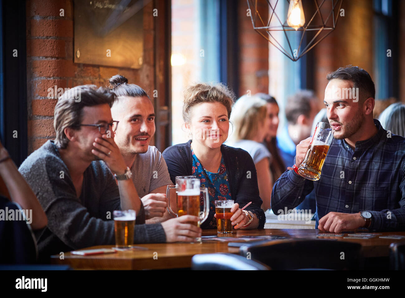 Bere nei pub alla moda giovani parlando di socializzare socializzare in chat incontro informale godendo azienda natter parlando discutere Foto Stock