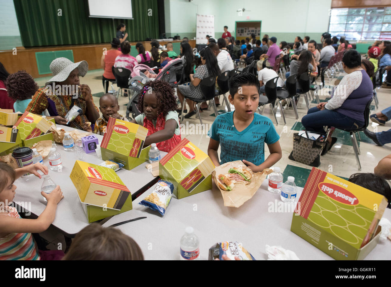 Genitori e figli di mangiare pranzo confezionato durante il programma estivo presso la scuola elementare di inglese per gli studenti di lingue in Austin TX Foto Stock
