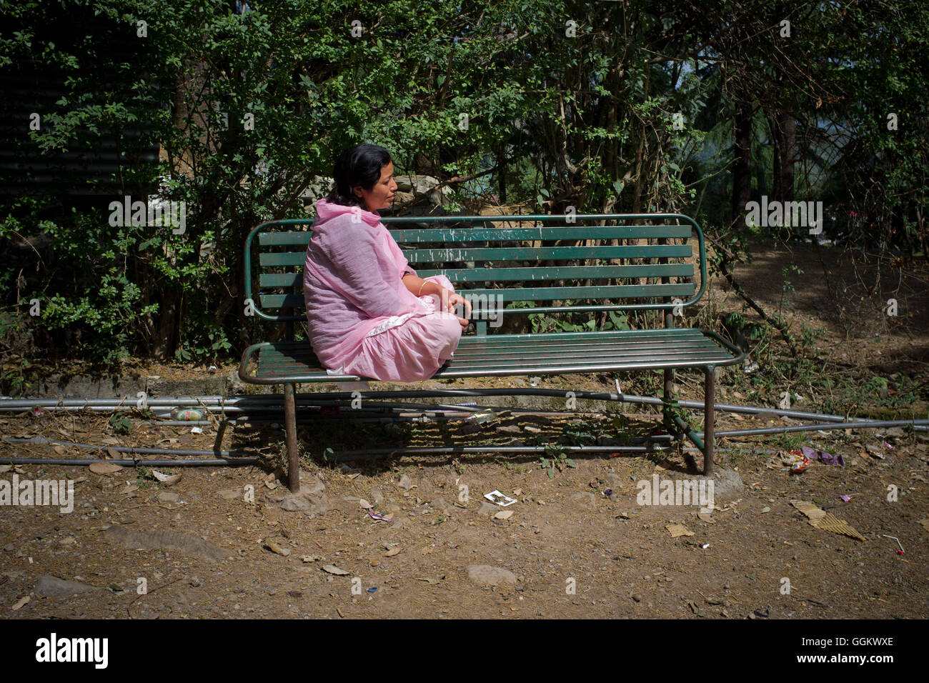 Donna seduta su una panchina in Mcleod Ganj Dharamsala, Himachal Pradesh, India. © Jordi Boixareu Foto Stock
