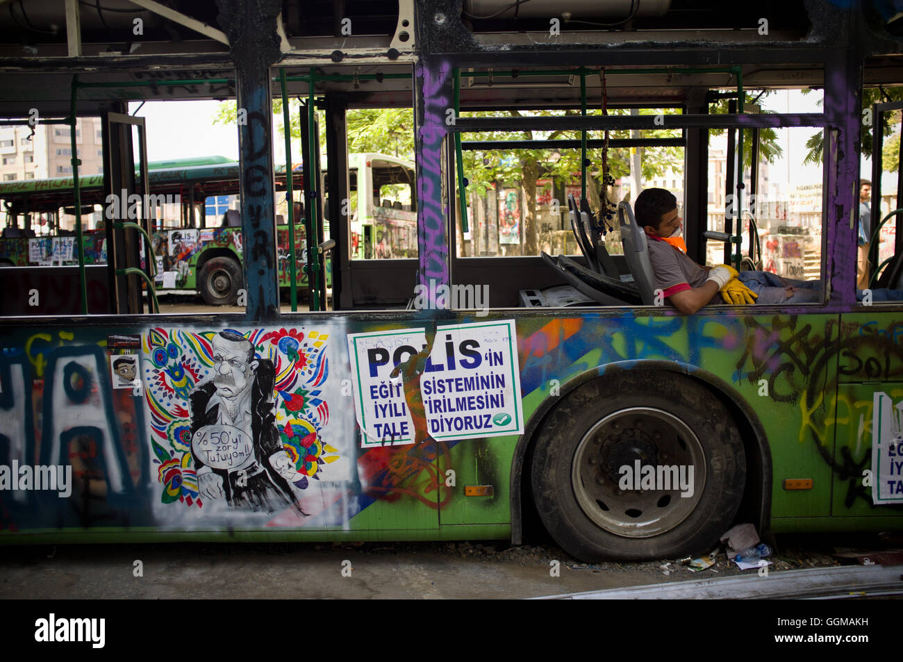 Un uomo mascherato dorme in un bus vandalizzato durante i disordini di piazza Taksim, Istanbul. © Jordi Boixareu Foto Stock