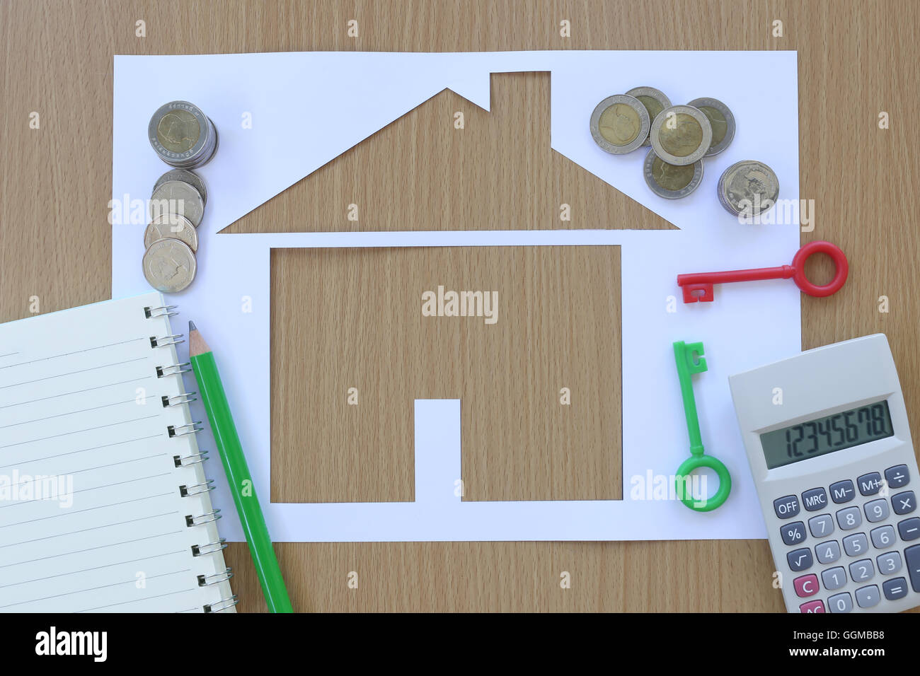 Carta casa sagomata su uno sfondo di legno marrone e artigiano attrezzo,idee per il concetto di design dell'edificio aziendale. Foto Stock