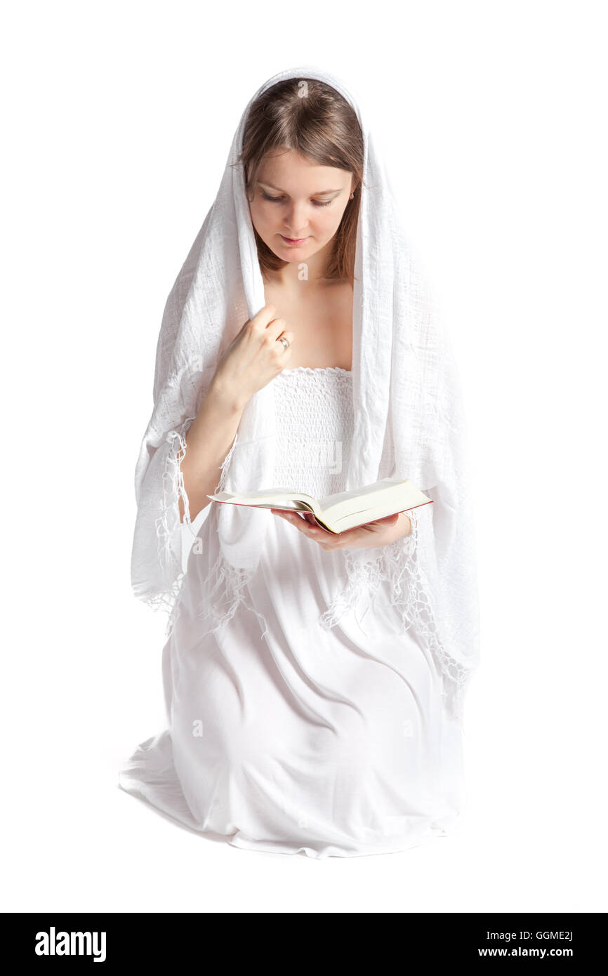 Giovane donna con un velo in ginocchio e la lettura della Bibbia. Isolato su uno sfondo bianco Foto Stock