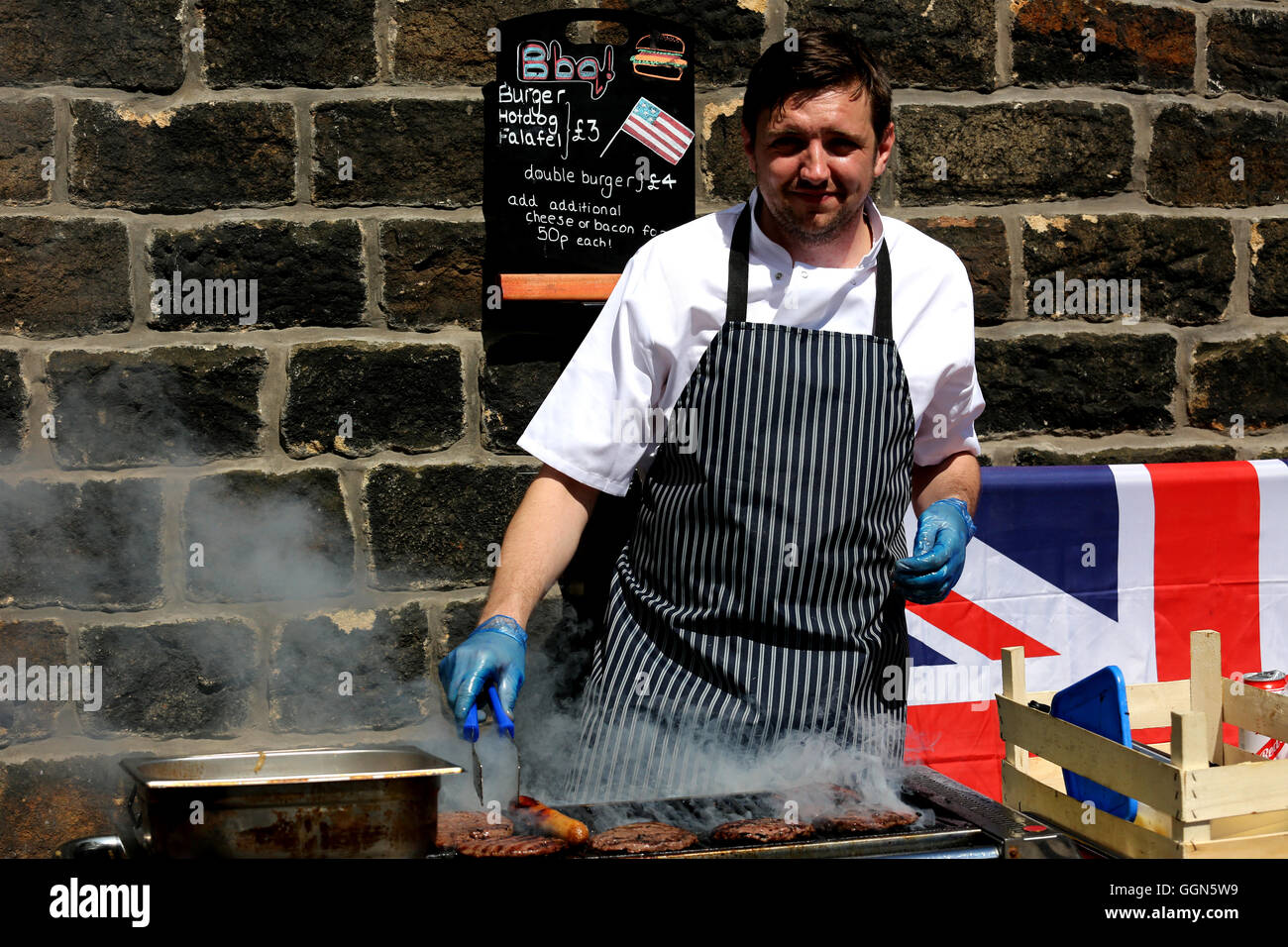 Saddleworth, UK. 06 Ago, 2016. Attore Graeme Proctor cottura su un barbecue in Uppermill, 6 agosto 2016 Credit: Barbara Cook/Alamy Live News Foto Stock