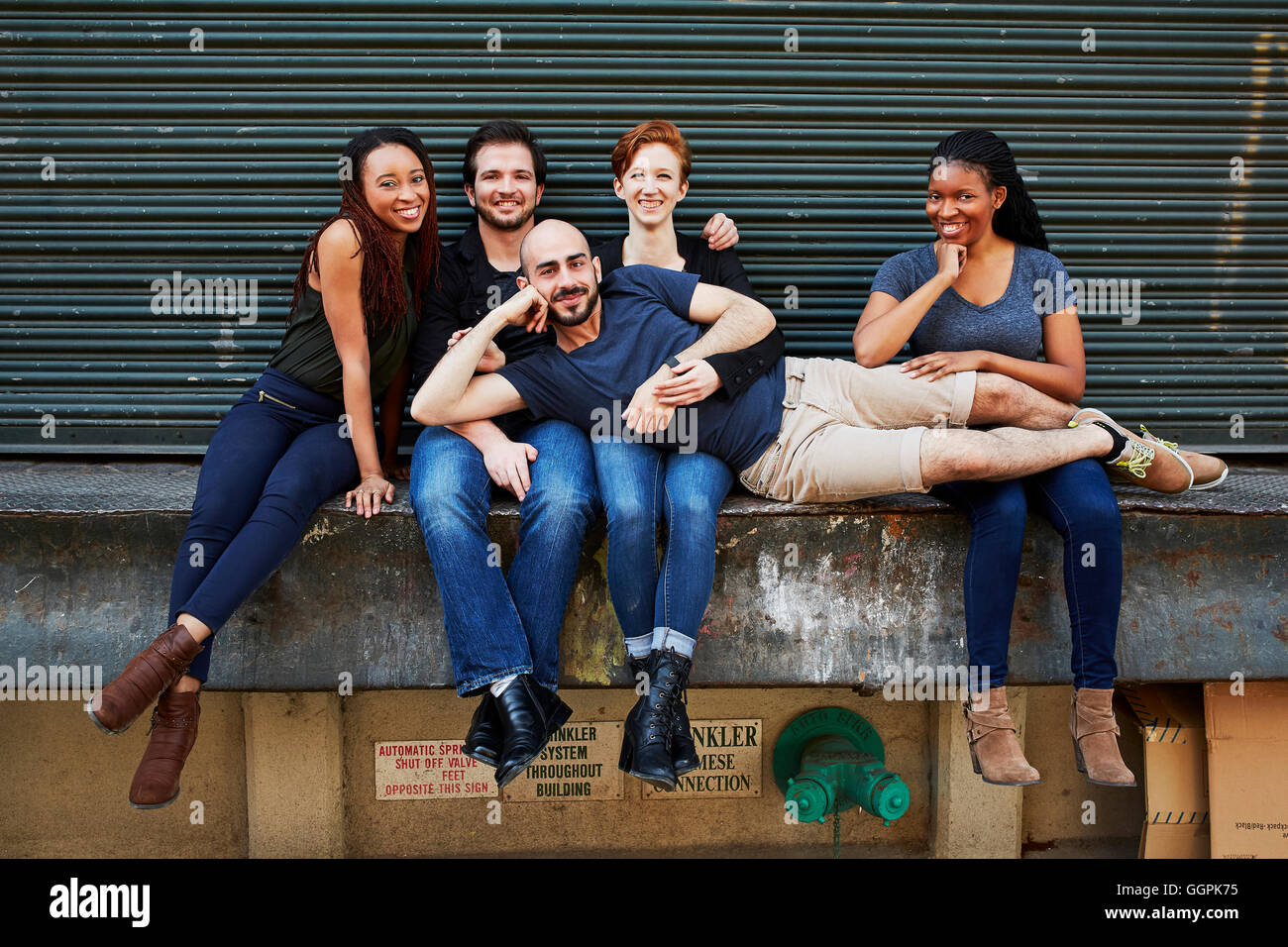 Uomo che stabilisce in giri di amici sulla banchina di carico Foto Stock