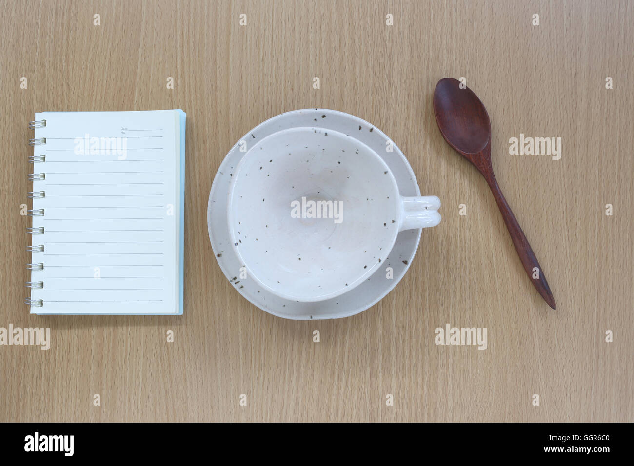 White tazza di caffè e note book in vista dall'alto su uno sfondo di legno per il design concept food. Foto Stock