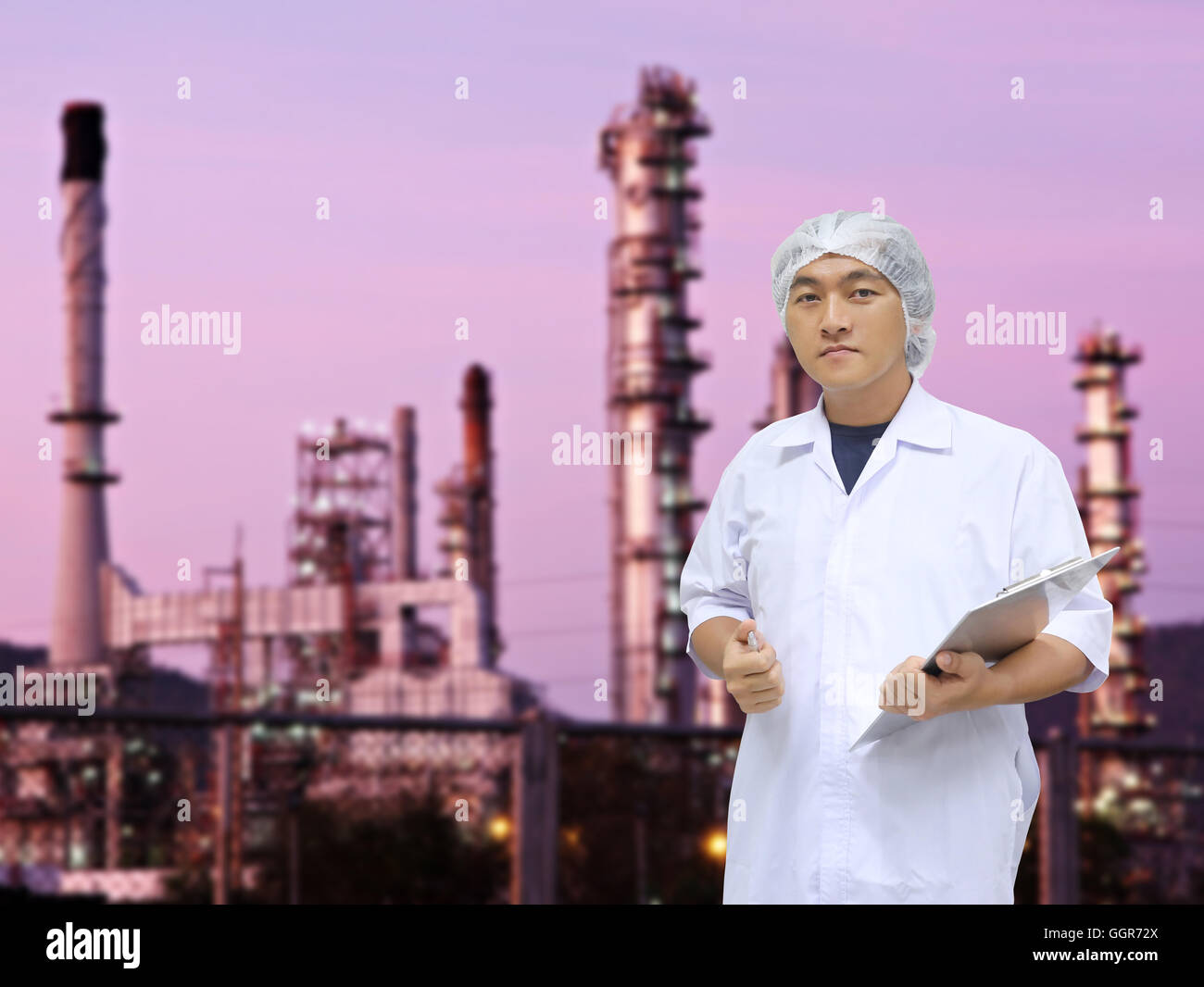 Un uomo in bianco grande mano uniforme e raffineria di petrolio di sfondo per il concept design di ispezione della qualità aziendale. Foto Stock
