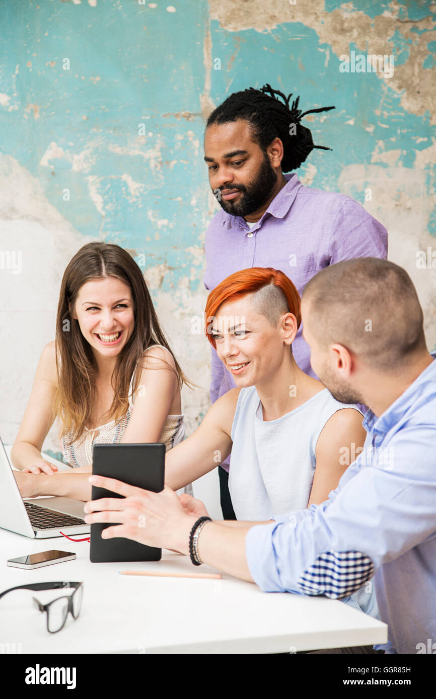 Giovani che lavorano con la scrivania in ufficio grunge Foto Stock