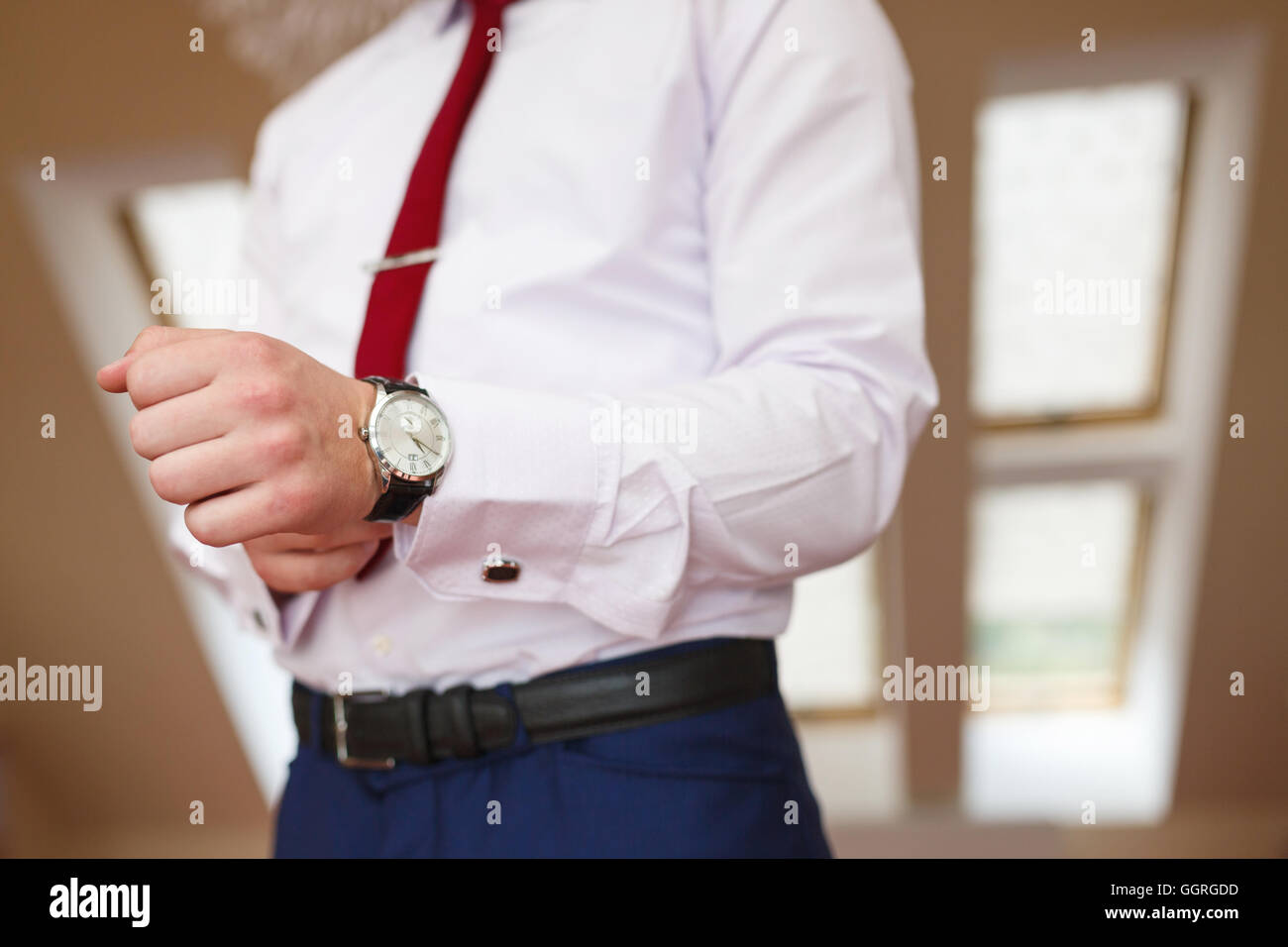 Lo sposo mette la mano sull'orologio Foto Stock