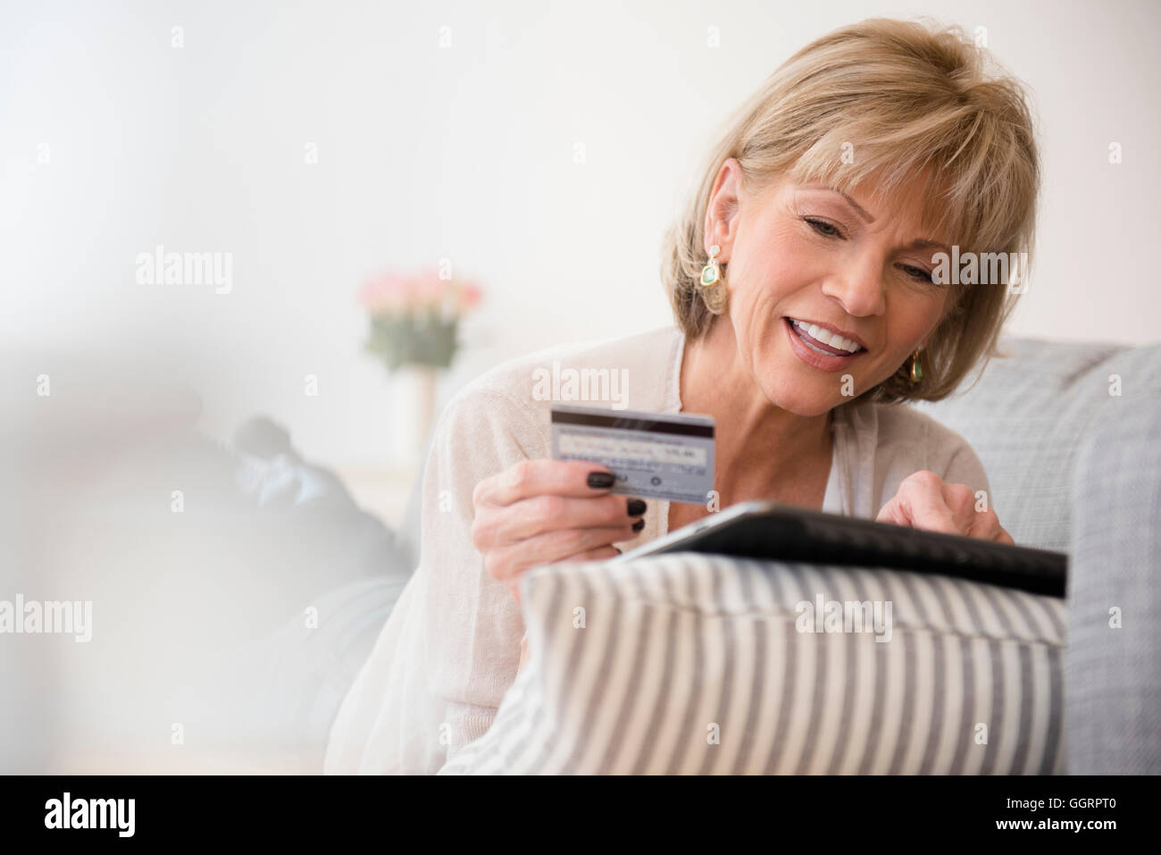 I vecchi donna caucasica shopping online con tavoletta digitale Foto Stock