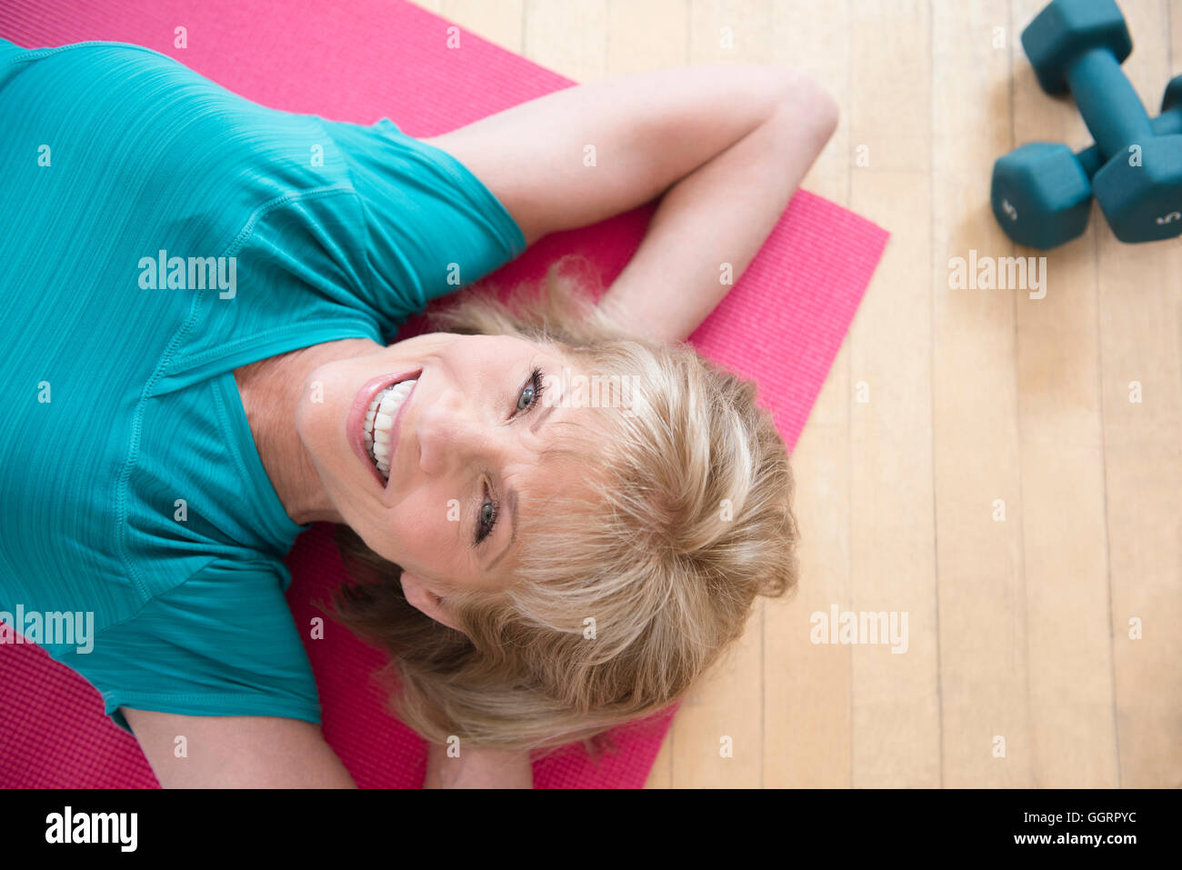 I vecchi donna caucasica rilassante sul tappeto di esercizio Foto Stock