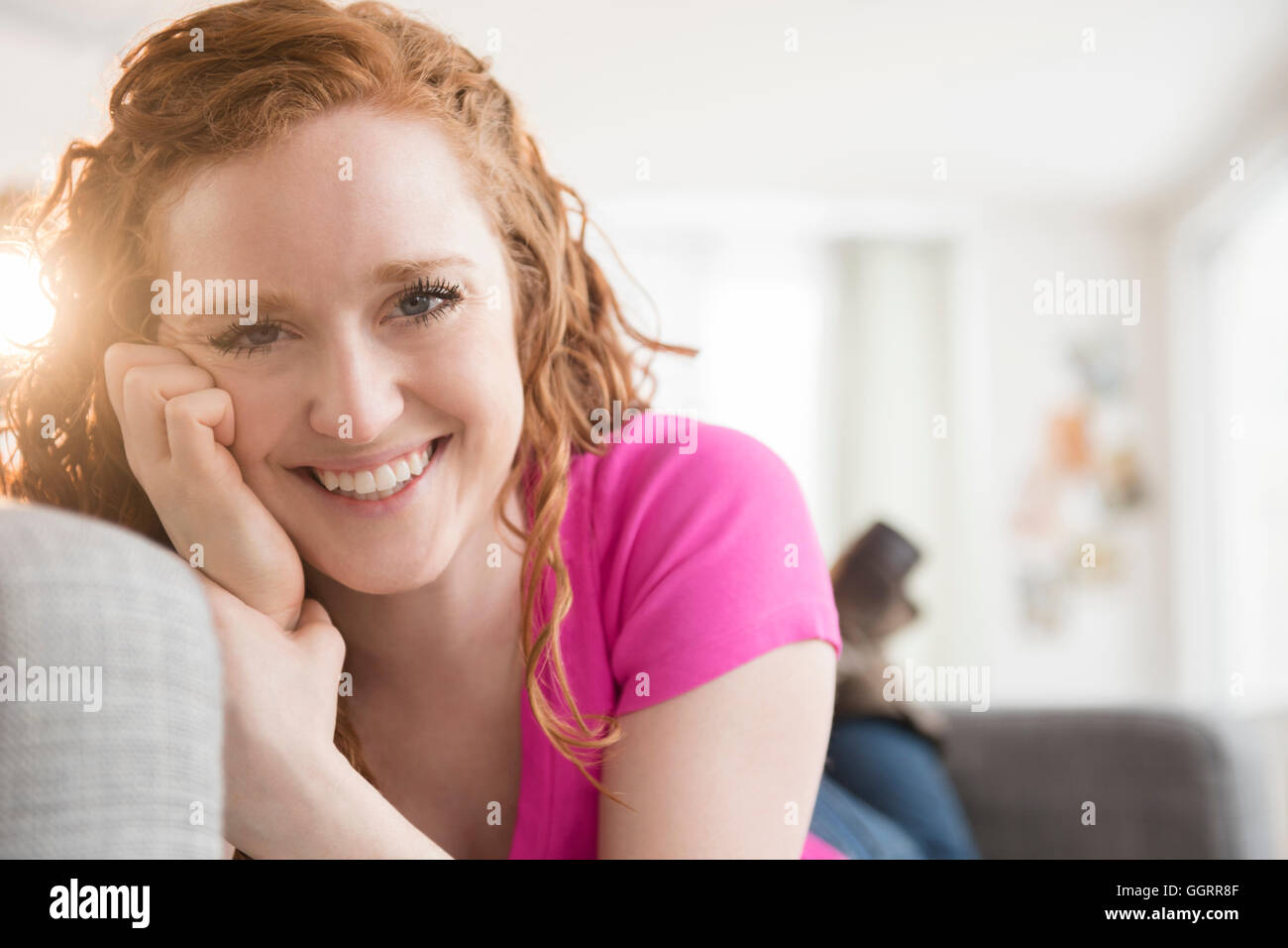 Sorridente donna caucasica la posa sul divano Foto Stock