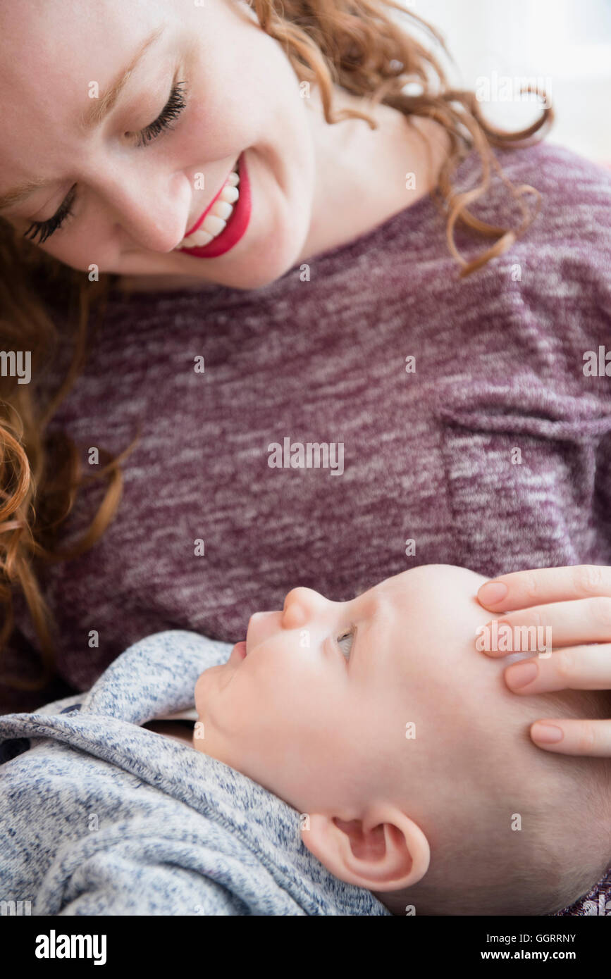 La donna caucasica holding baby figlio in giro Foto Stock
